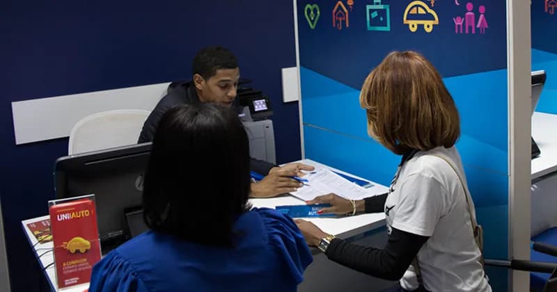 Funcionário da Universal Seguros da agência do Morro Bento atendendo clientes.
